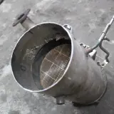 Filtr DPF, czyli co to jest? Widoczny element układu wydechowego z charakterystycznym, siatkowanym wkładem.