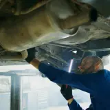 Mechanik bada podwozie Opla, szukając przyczyny błędu DTC P0420.