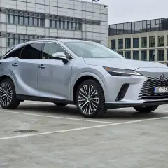 Srebrny Lexus 350 zaparkowany przed nowoczesnym budynkiem biurowym.