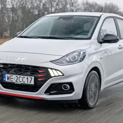 Biały Hyundai i10 N Line w ruchu, z widocznym grillem i światłami. Sprawdź aktualną hyundai i10 cena.