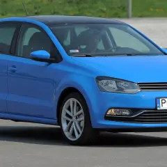 Niebieski VW Polo 2010 z czarnym dachem, zaparkowany na zewnątrz.