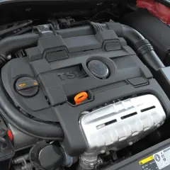 Silnik TSI z widocznym logo VW. Widoczne elementy układu dolotowego i osłony silnika.