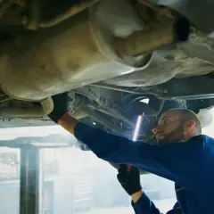 Mechanik bada podwozie Opla, szukając przyczyny błędu DTC P0420.
