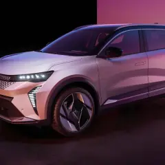 Nowy Renault Scenic 3, elektryczny SUV, prezentuje się w stylowym, różowo-fioletowym oświetleniu.