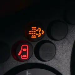 Kontrolka filtra cząstek stałych (DPF) świeci się na pomarańczowo, sygnalizując potrzebę wypalania DPF. Obok świeci się kontrolka otwartych drzwi.