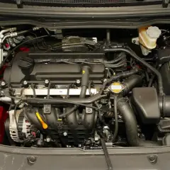 Silnik Hyundai i20 2010. Widoczny alternator, akumulator, płyny i przewody.