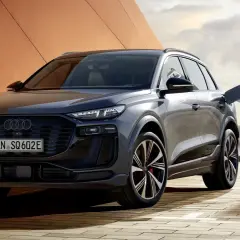 Elegancki Audi SQ6 z wtyczką ładowania podłączoną do stacji. Nowoczesny design i ekologiczna energia.