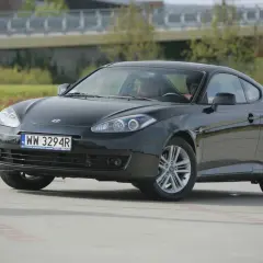 Czarny Hyundai Coupe 2.7 V6 z przyciemnionymi szybami i sportowymi felgami, zaparkowany na zewnątrz.