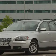 Srebrne Volvo V50 1.6 diesel na tle nowoczesnego budynku.