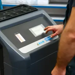 Mechanik dotyka ekranu maszyny do adaptacji skrzyni biegów, przygotowując ją do czyszczenia.