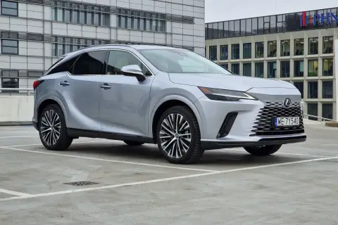 Srebrny Lexus 350 zaparkowany przed nowoczesnym budynkiem biurowym.