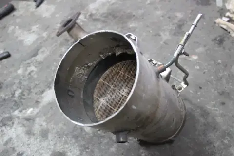 Filtr DPF, czyli co to jest? Widoczny element układu wydechowego z charakterystycznym, siatkowanym wkładem.