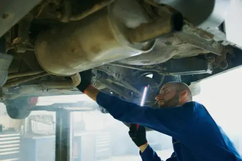 Mechanik bada podwozie Opla, szukając przyczyny błędu DTC P0420.