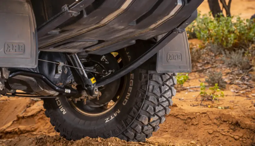 Koło terenowe z oponą MTZ na piasku, podwozie pojazdu z osłoną ARB. Idealny do off-roadu i resorowania.