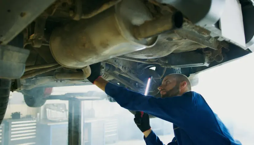Mechanik bada podwozie Opla, szukając przyczyny błędu DTC P0420.