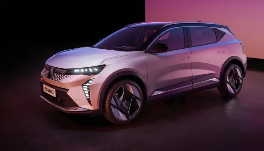 Nowy Renault Scenic 3, elektryczny SUV, prezentuje się w stylowym, różowo-fioletowym oświetleniu.