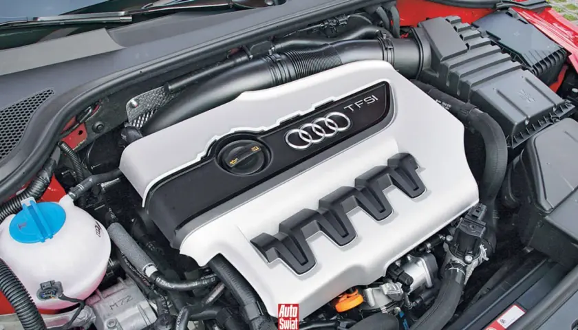 Silnik 2.0 TFSI z Audi A5, gotowy do pracy. Widoczna pokrywa silnika z logo Audi i oznaczeniem TFSI.