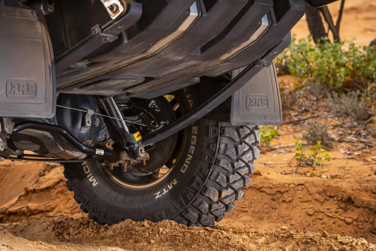 Koło terenowe z oponą MTZ na piasku, podwozie pojazdu z osłoną ARB. Idealny do off-roadu i resorowania.