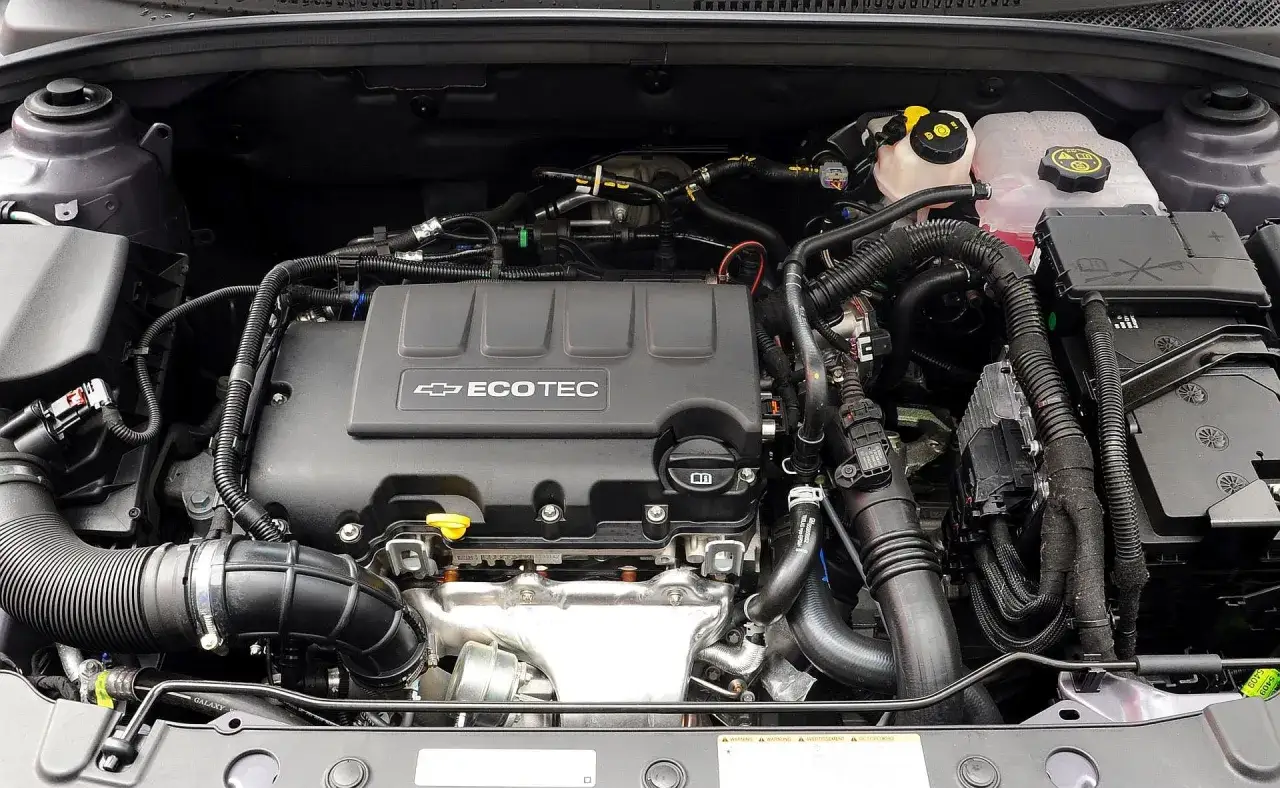 Silnik Ecotec Chevrolet Cruze 1.8 benzyna. Widok komory silnika z widocznymi elementami układu dolotowego i chłodzenia.