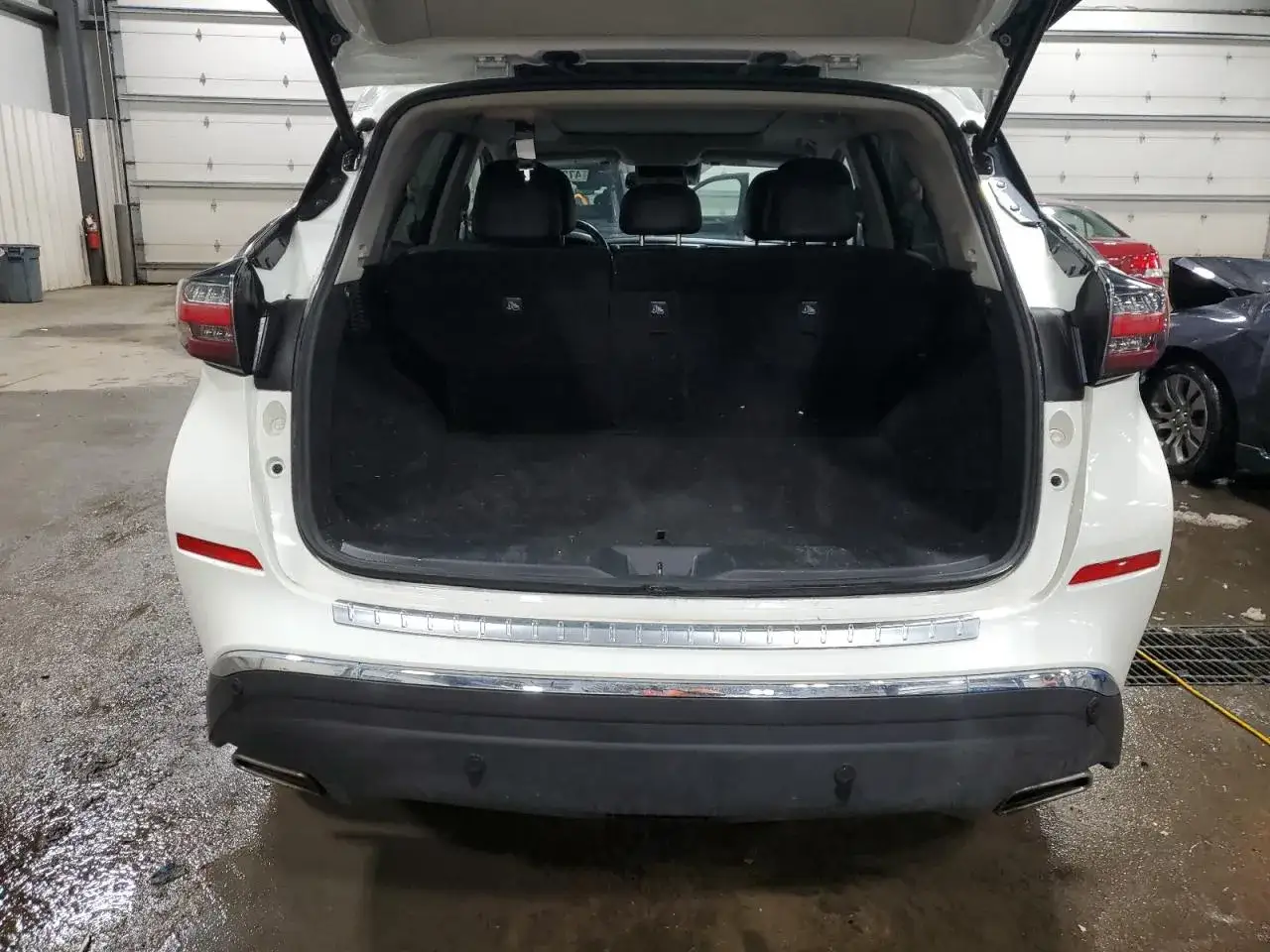 Biały Nissan Murano 3.5 V6 z otwartym bagażnikiem. Wnętrze czyste, gotowe na podróż.