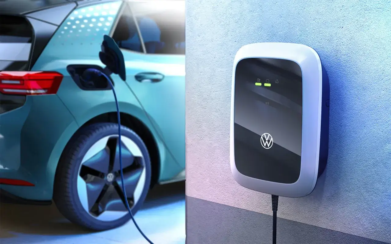 Ładowanie Volkswagena ID4. Stacja ładowania z logo VW na ścianie i podłączony do samochodu kabel.