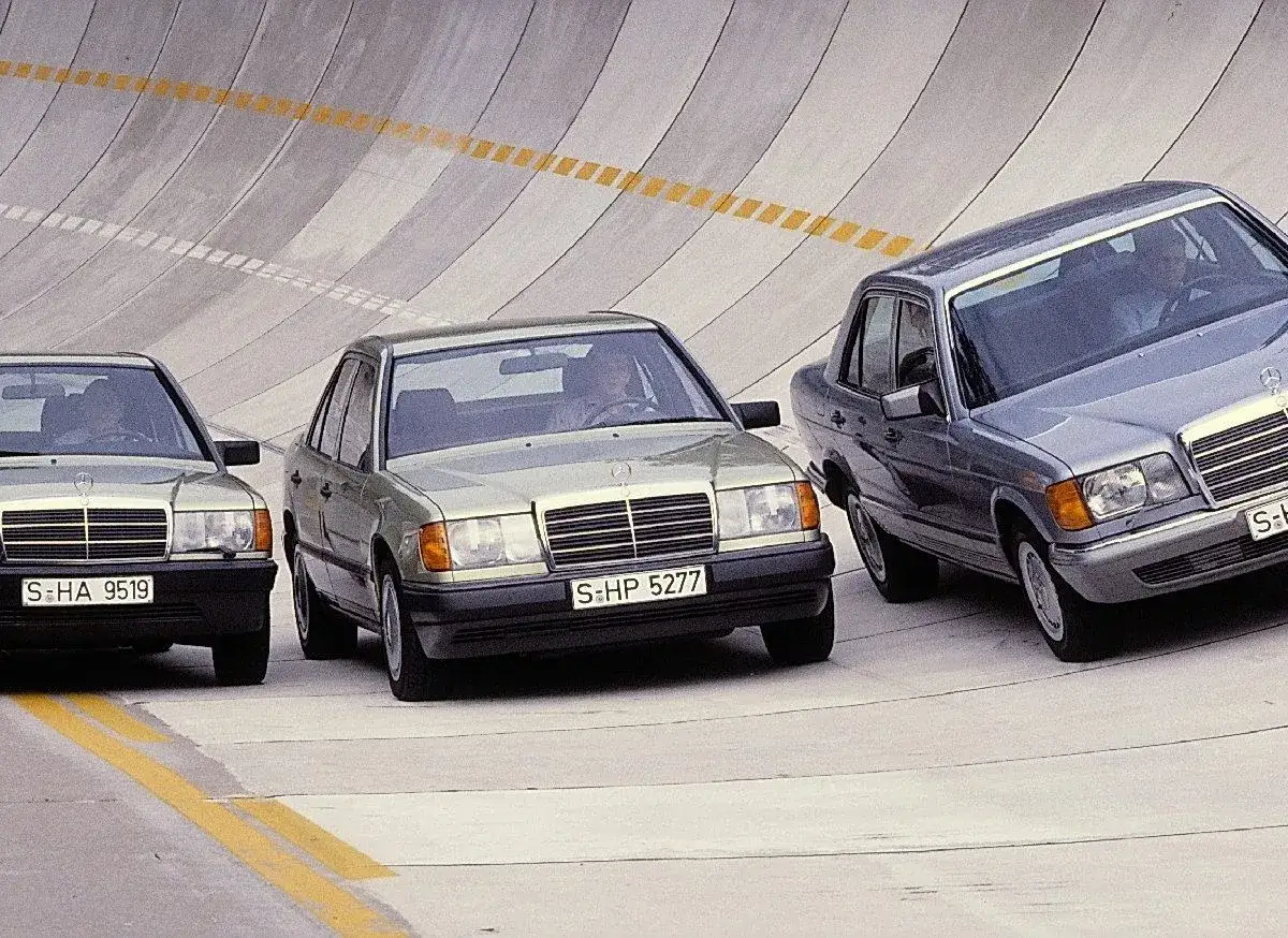 Trzy klasyczne Mercedesy 200 jadą po betonowym torze.