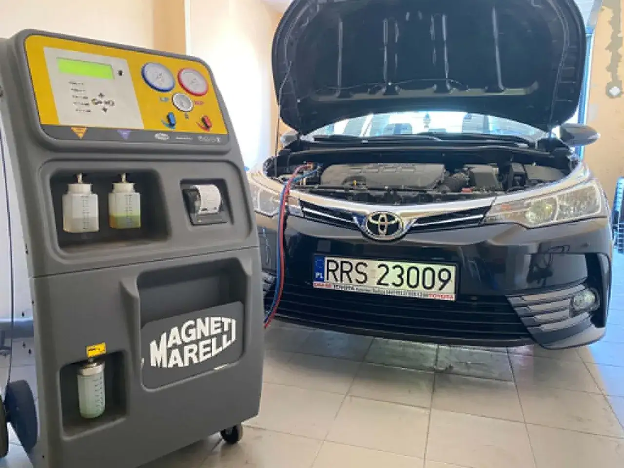 Stacja do obsługi klimatyzacji samochodowej Magneti Marelli obok Toyoty. Sprawdzanie, ile czynnika do klimatyzacji pozostało.