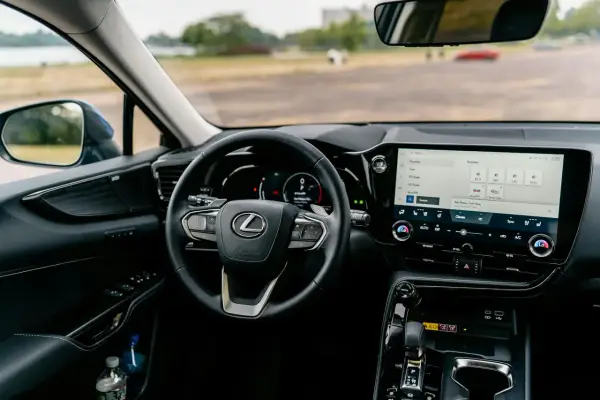 Wnętrze Lexusa z ekranem multimedialnym, na którym widać opcje radia i nawigacji, sugerujące android auto aktualizacja.